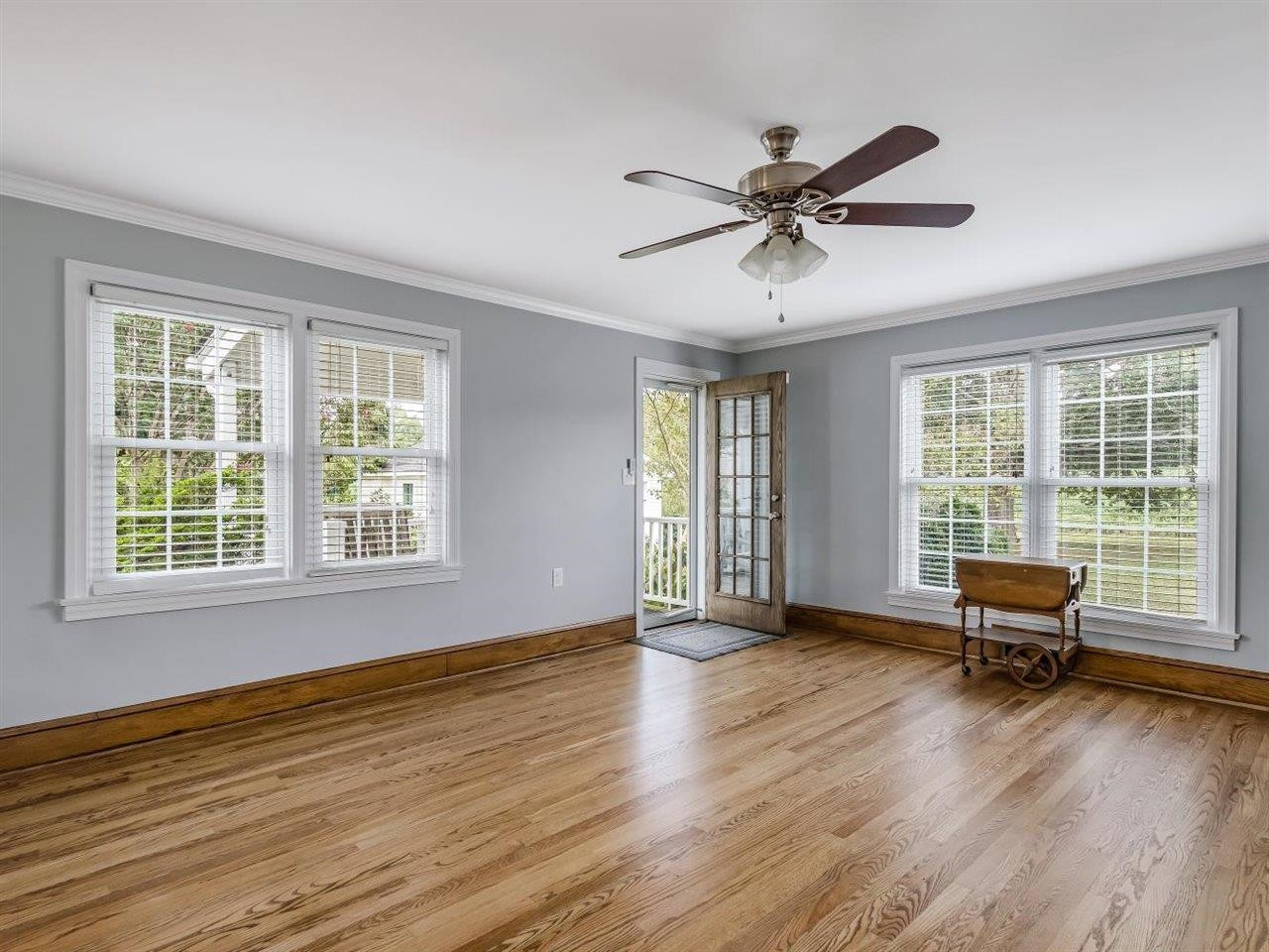 5609 Dona Road Julian, NC 27283 - Photo 15 of 63 a view of a livingroom with wooden floor a ceiling fan and windows