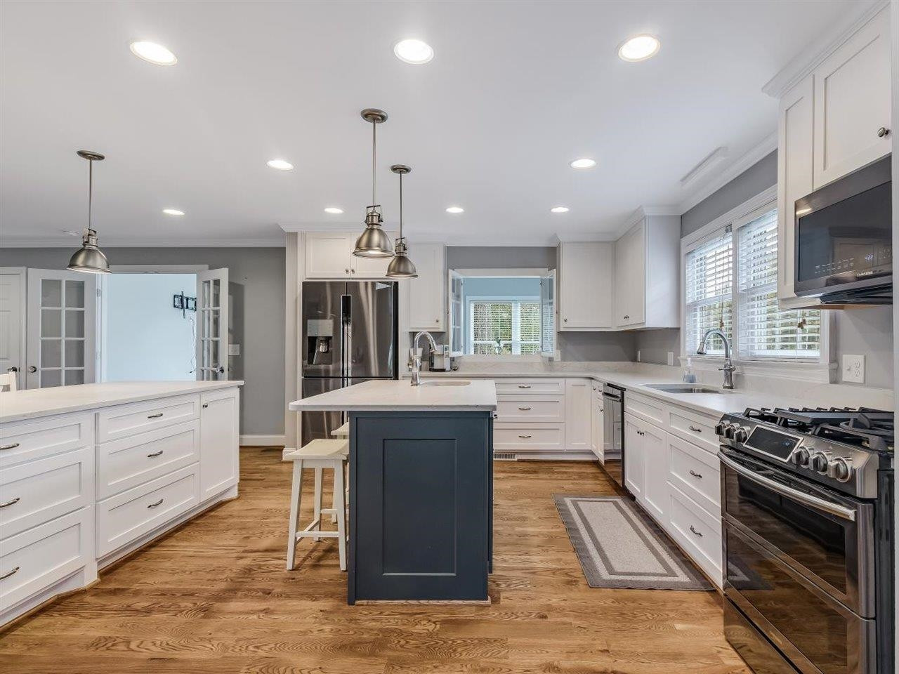 5609 Dona Road Julian, NC 27283 - Photo 19 of 63 a kitchen with kitchen island granite countertop a stove top oven a sink dishwasher a dining table and chairs with wooden floor