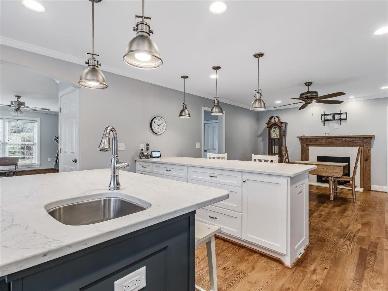 5609 Dona Road Julian, NC 27283 - Photo 23 of 63 a kitchen with a sink a center island a stove and a wooden floor