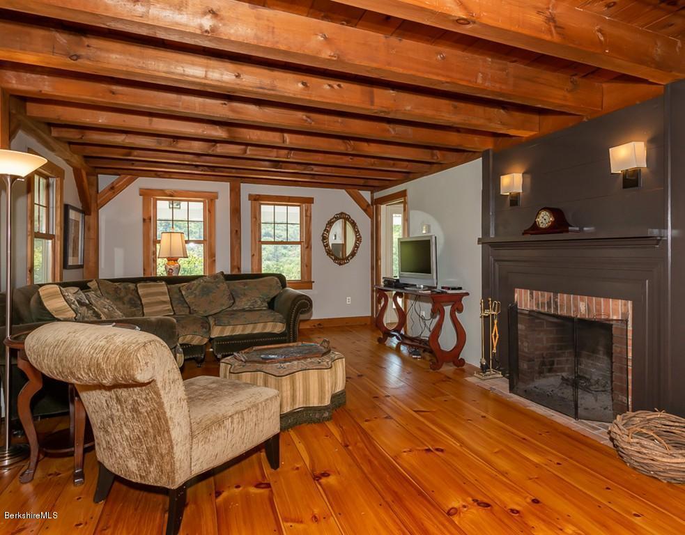430 East River Road Chester, MA 01011 - Photo 15 of 42 a living room with furniture a fireplace and a dining table with wooden floor