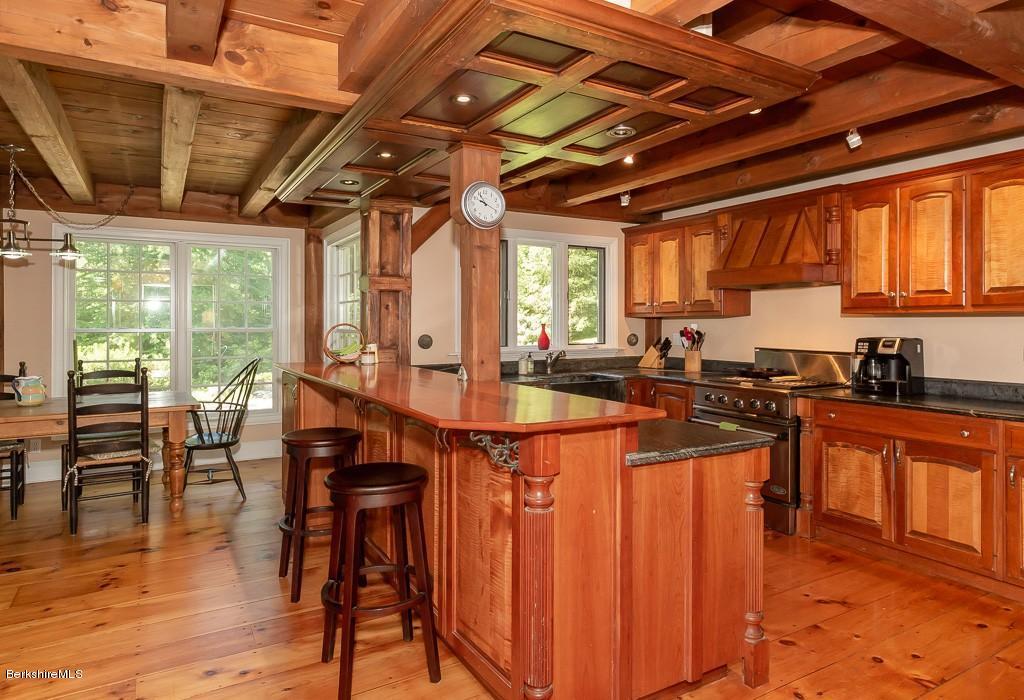 430 East River Road Chester, MA 01011 - Photo 23 of 42 a kitchen with stainless steel appliances granite countertop a stove a sink dishwasher and chairs with wooden floor