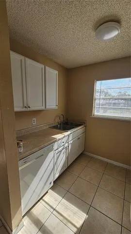 a kitchen with a sink a stove cabinets and utility room