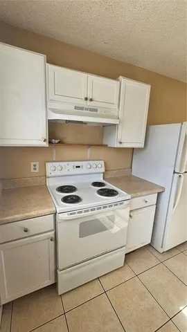 a stove top oven sitting inside of a kitchen