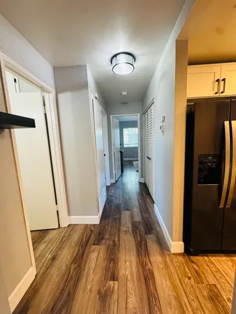 a view of a hallway with wooden floor and staircase