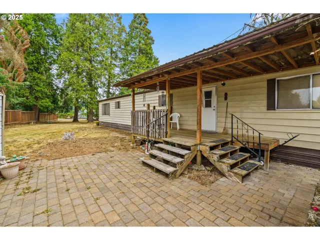 a backyard of a house with barbeque oven table and chairs