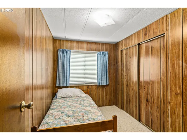 a view of a bedroom with wooden floor and windows