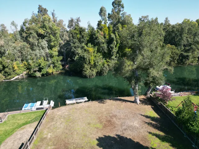 a backyard of a house with lots of green space and lake view
