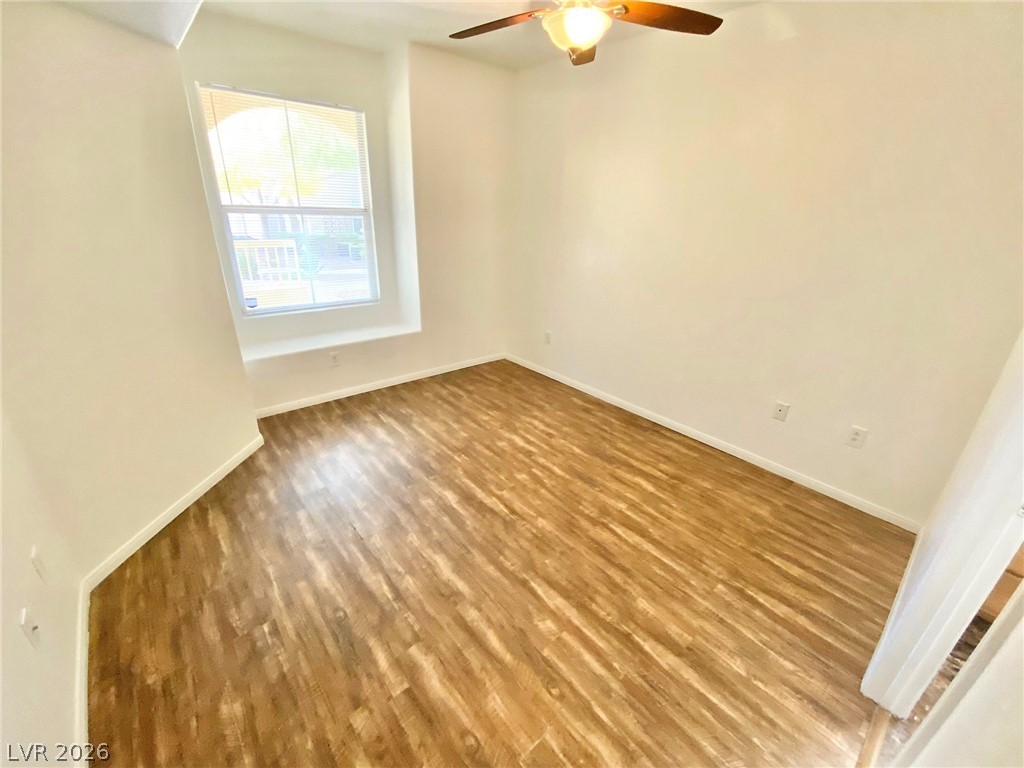 10550 West Alexander Road, Unit 1131 Las Vegas, NV 89129 - Photo 8 of 18 A well-lit bedroom features durable laminate flooring and a functional ceiling fan for comfort.
