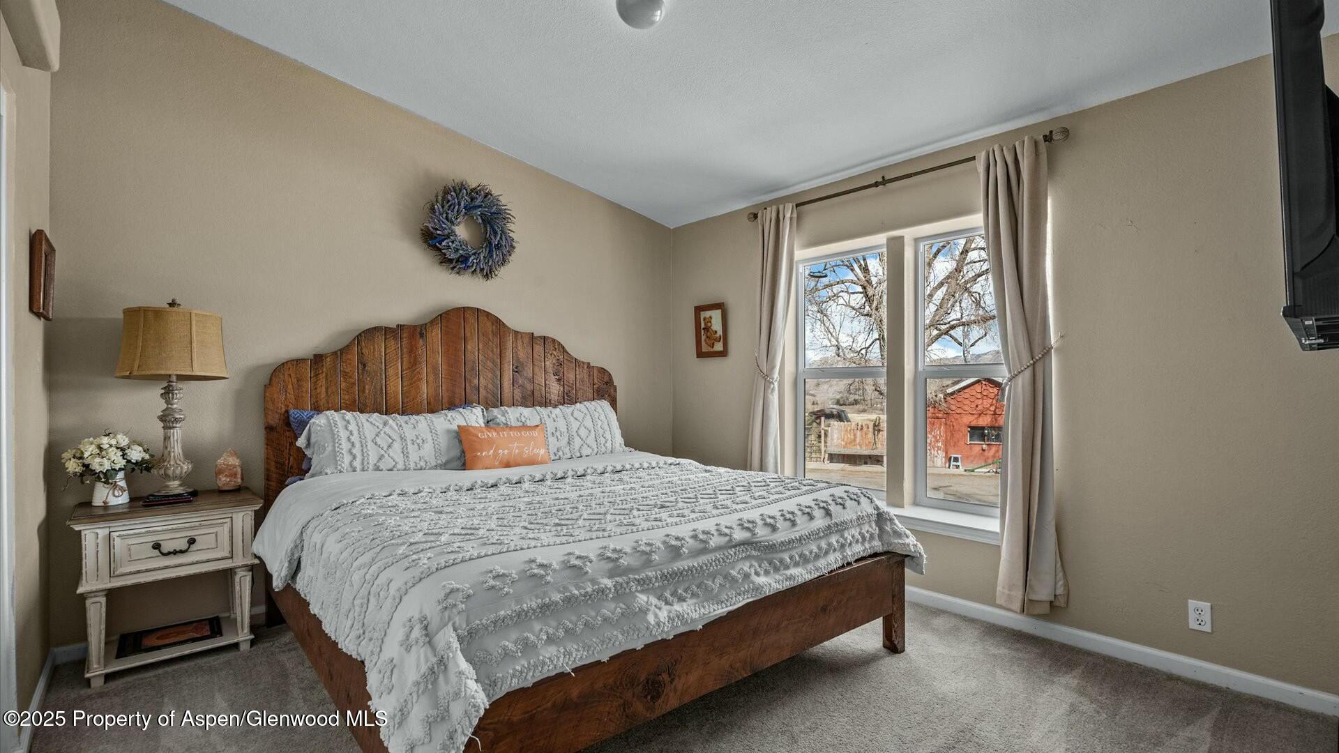 10479 50 Road Mesa, CO 81643 - Photo 24 of 42 a bedroom with a bed a wall painting and a window