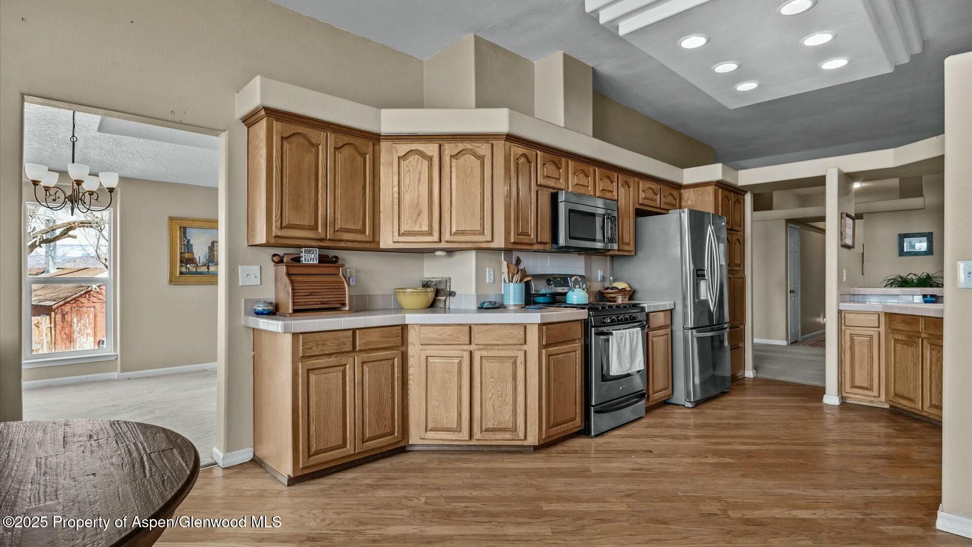 10479 50 Road Mesa, CO 81643 - Photo 10 of 42 a kitchen with stainless steel appliances granite countertop a refrigerator a stove top oven a sink and dishwasher