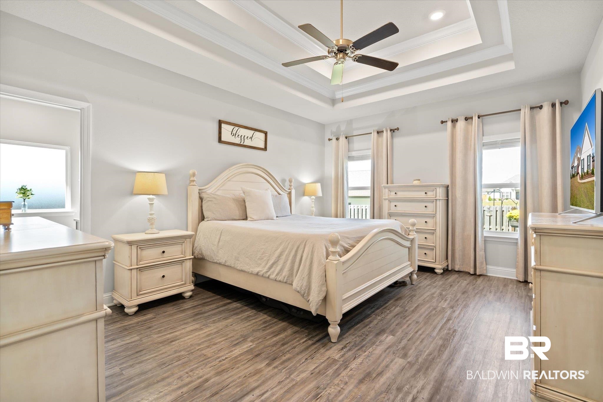 12899 Sanderling Loop Daphne, AL 36527 - Photo 13 of 28 Bedroom with a tray ceiling, multiple windows, dark hardwood / wood-style floors, and ceiling fan