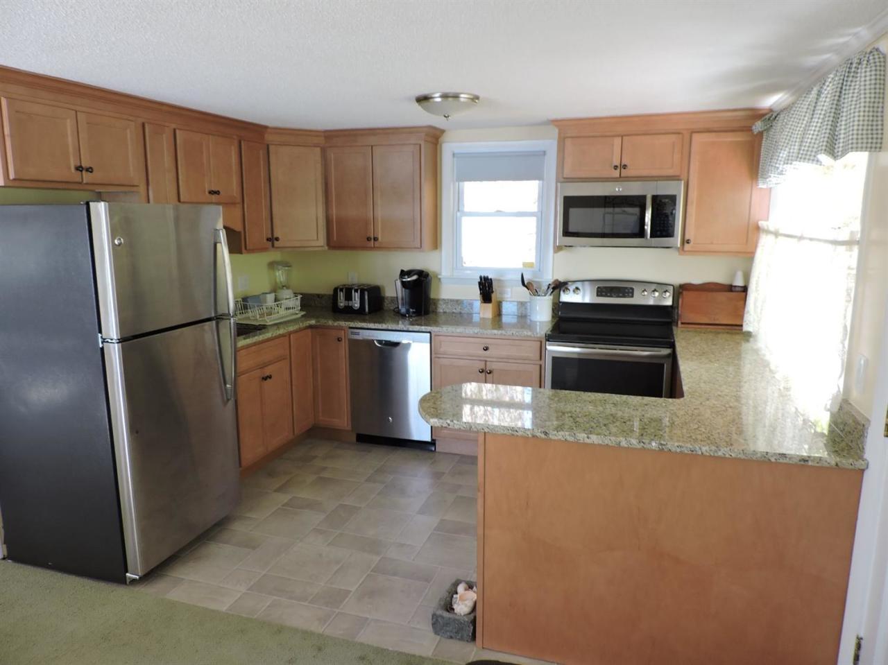 85 Huckins Neck Road Centerville, MA 02632 - Photo 10 of 23 a kitchen with stainless steel appliances granite countertop a refrigerator a stove a sink a microwave and cabinets