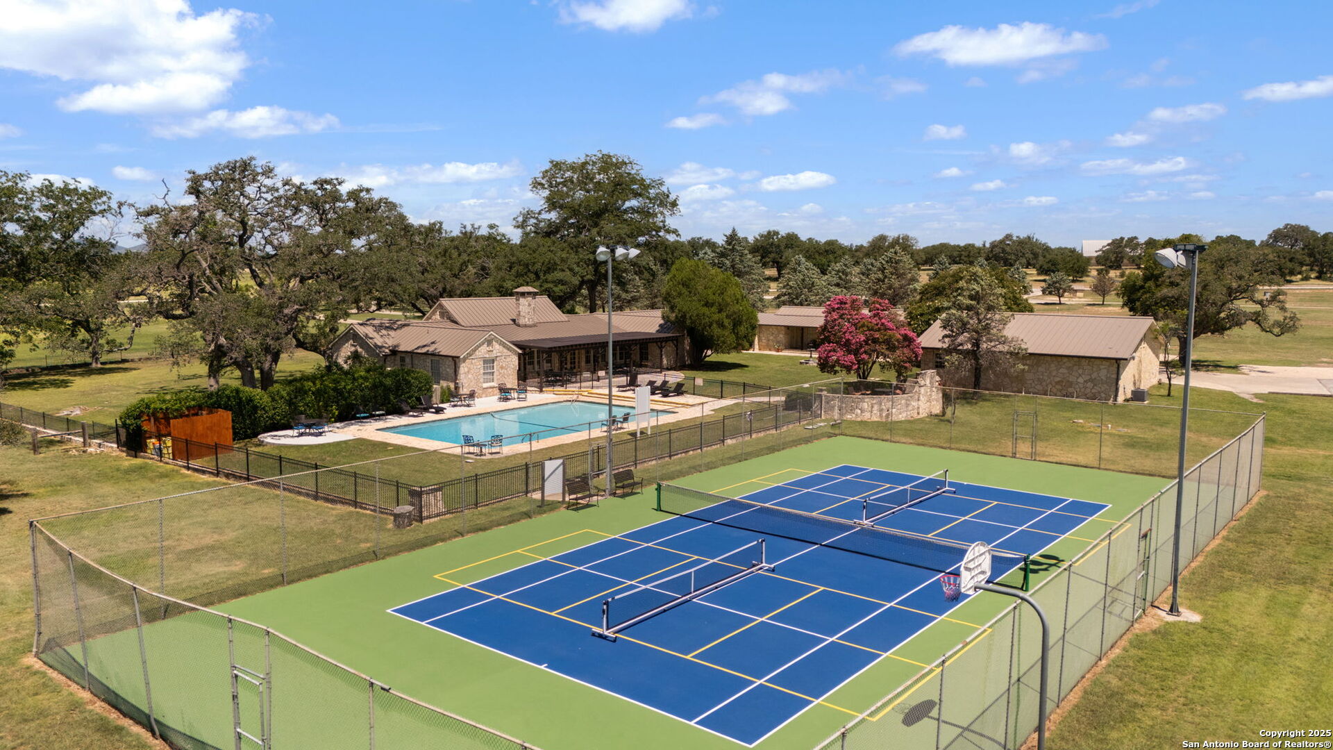 1005 Buckskin Trail Bandera, TX 78003 - Photo 5 of 27 a view of a tennis ground with seating area and barbeque oven