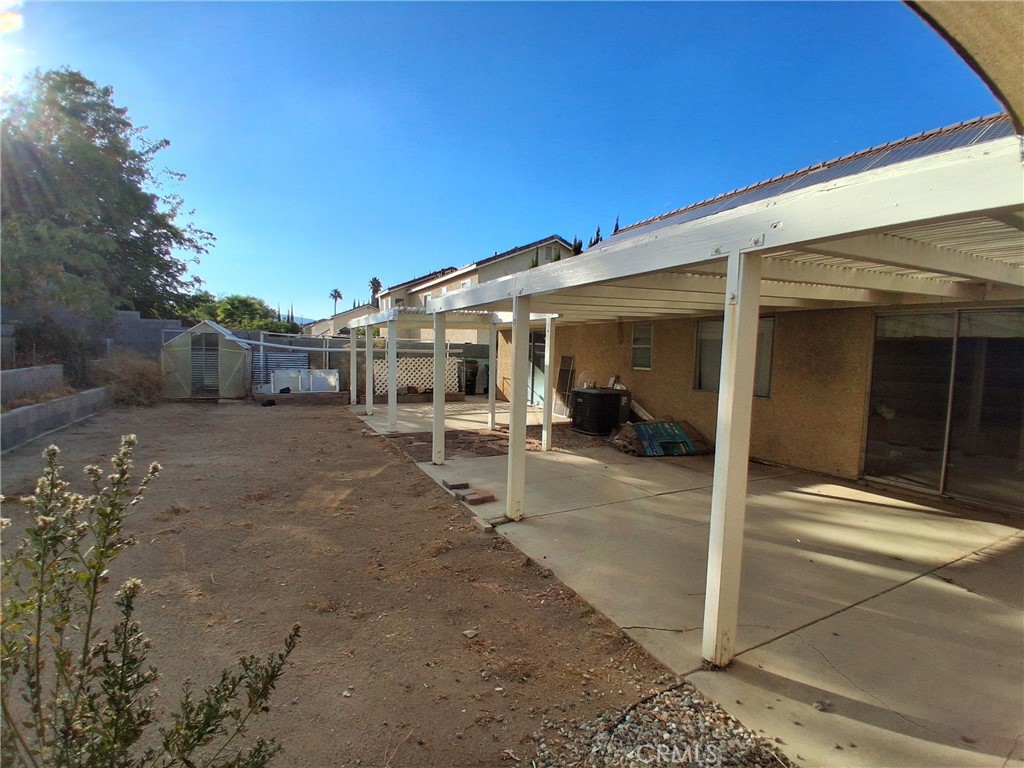 566 East Ave R8 Palmdale, CA 93550 - Photo 22 of 25 a view of a patio with table and chairs and a floor to ceiling window