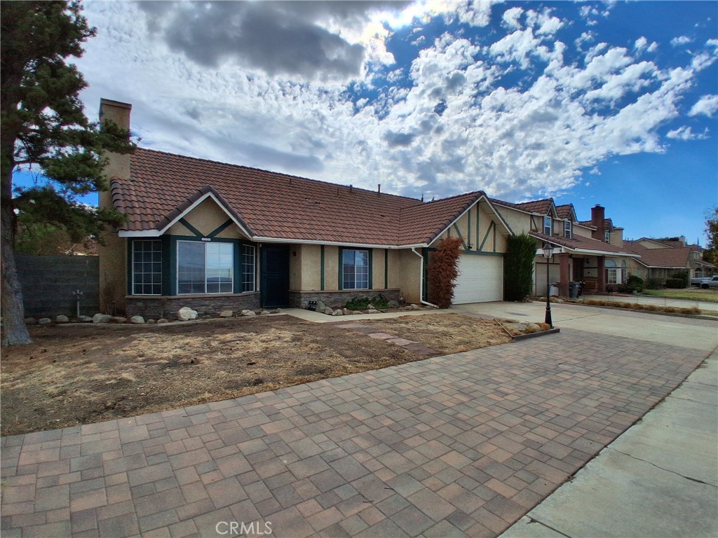 566 East Ave R8 Palmdale, CA 93550 - Photo 5 of 25 a front view of a house with a yard and garage