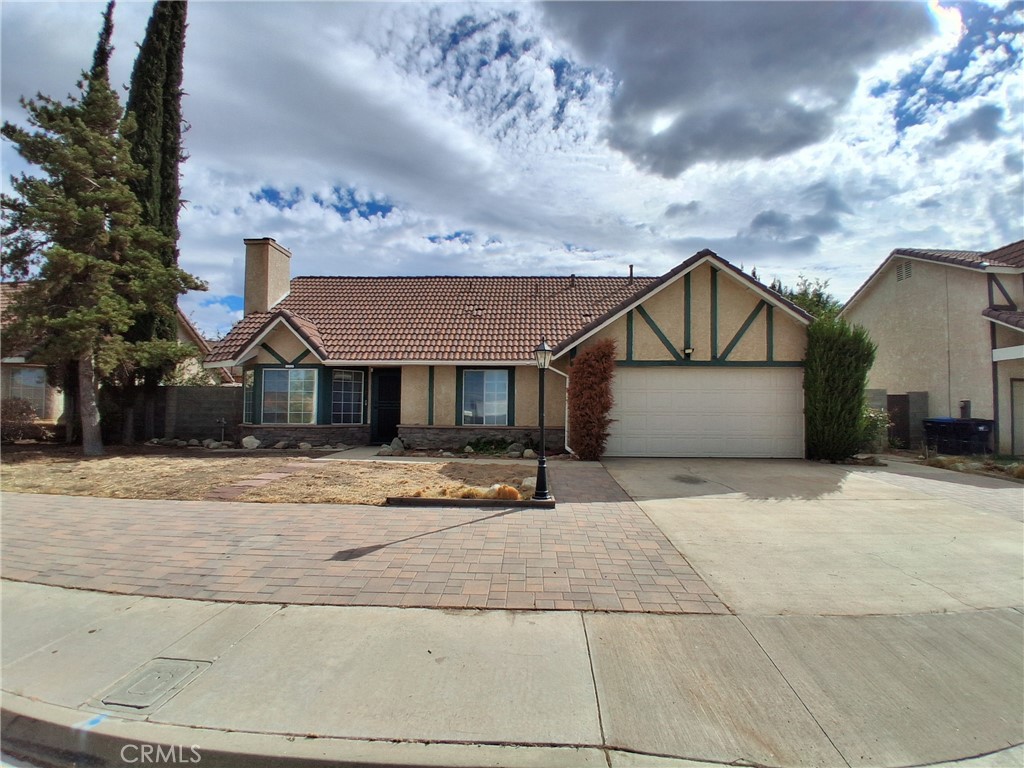 566 East Ave R8 Palmdale, CA 93550 - Photo 6 of 25 a front view of a house with a yard and garage