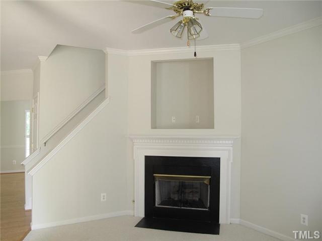 1100 Garnet Ridge Way Raleigh, NC 27607 - Photo 3 of 14 a living room with a fireplace and a ceiling fan