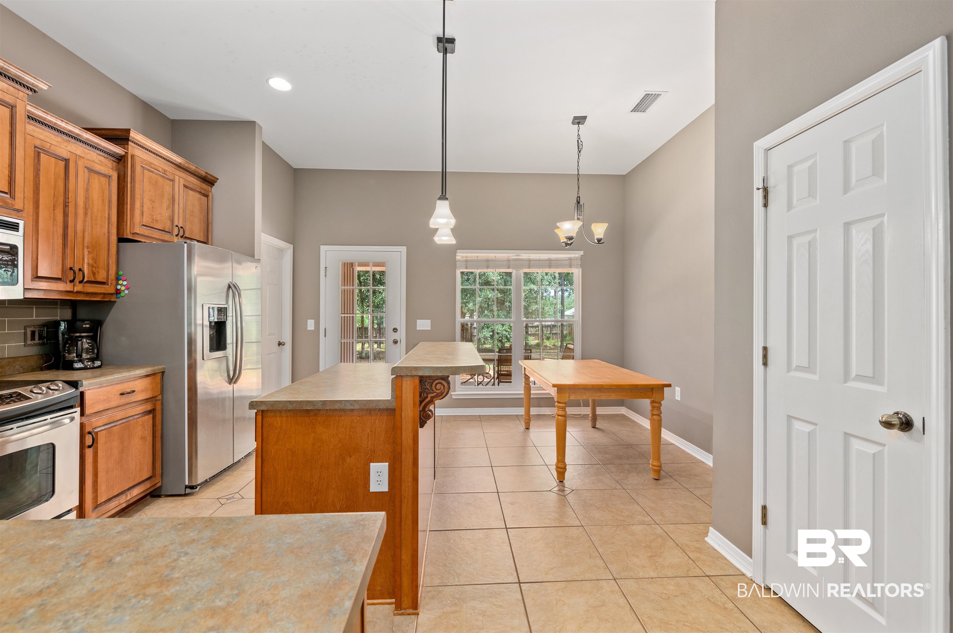 15240 Styx River Road Stapleton, AL 36578 - Photo 15 of 18 Kitchen with tasteful backsplash, white appliances, a kitchen island, decorative light fixtures, and a notable chandelier