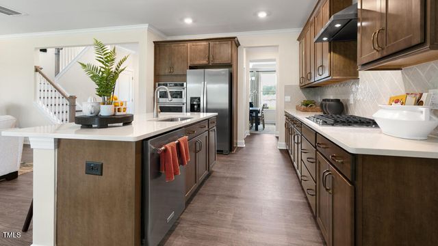 a kitchen with stainless steel appliances granite countertop a sink a stove and a refrigerator