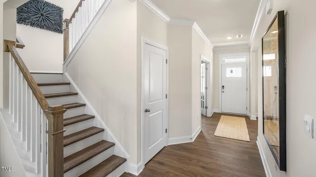 a view of a hallway with wooden floor and entryway