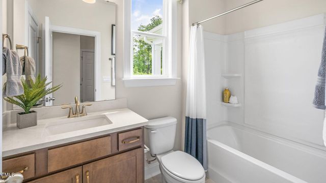 a bathroom with a sink a toilet a mirror a bathtub and shower