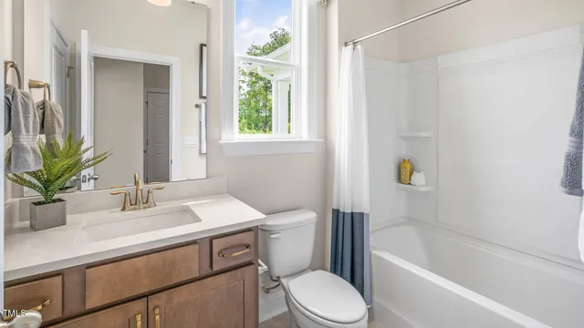 a bathroom with a sink a toilet a mirror a bathtub and shower