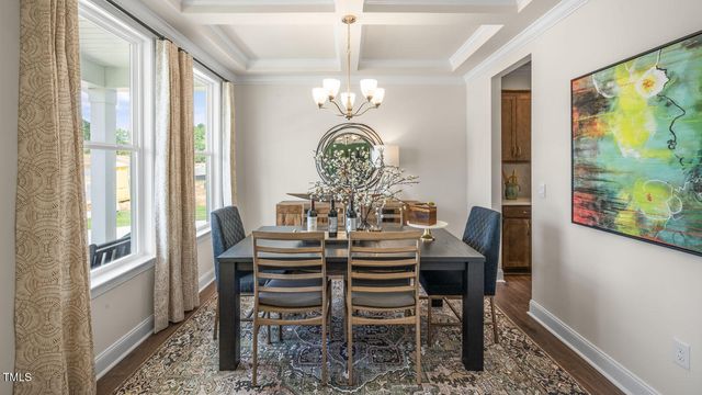 a view of a dining room with furniture a chandelier and a window