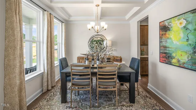a view of a dining room with furniture a chandelier and a window