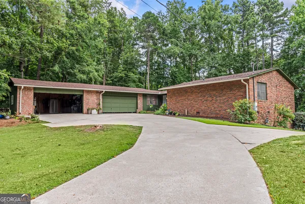 a front view of a house with a garden and yard