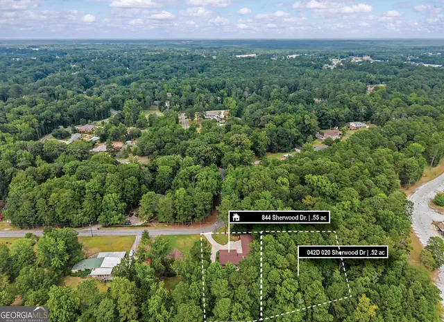 an aerial view of a house with a yard and outdoor seating