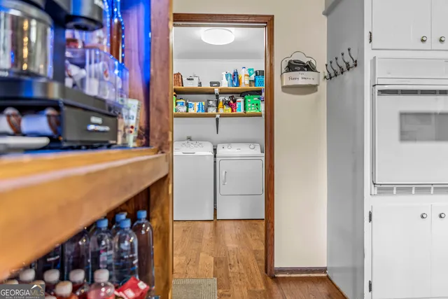 a kitchen with stainless steel appliances kitchen island granite countertop a sink dishwasher stove top oven and cabinets with wooden floor