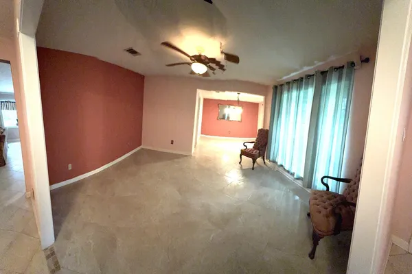 a view of a livingroom with a ceiling fan and window