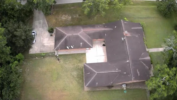 an aerial view of a house with a yard and a lake view