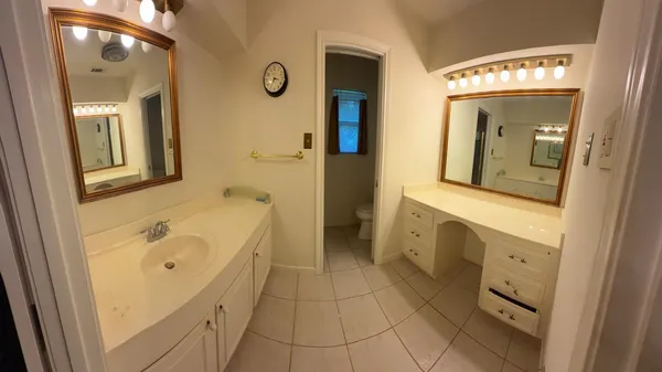 a bathroom with a tub a sink and a mirror