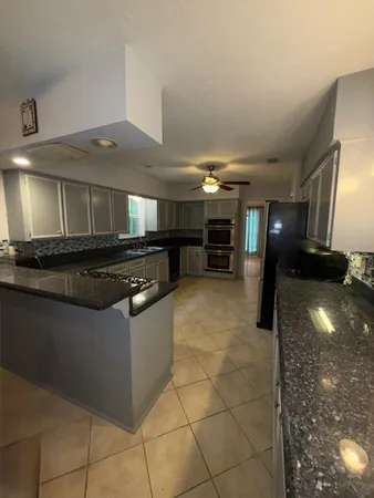 a kitchen with granite countertop a stove and cabinets