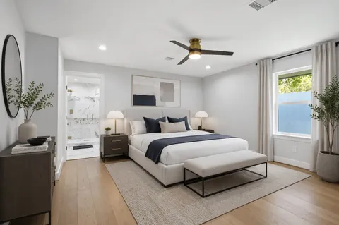 a spacious bedroom with a bed and a chandelier