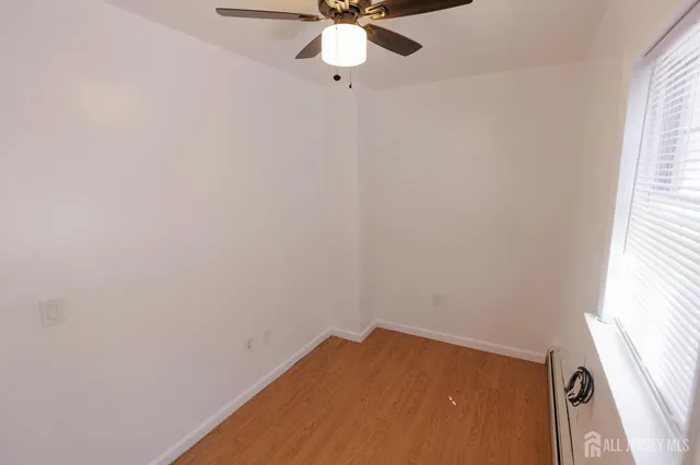a view of a room with a window and a ceiling fan