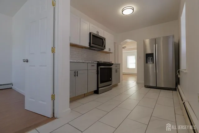 a kitchen with stainless steel appliances granite countertop a refrigerator and a stove top oven