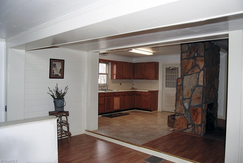 429 Hege Road Lexington, NC 27295 - Photo 7 of 29 Open kitchen-dining area features recently refurbished rock fireplace on dining room side and flue for wood cook stove on kitchen side. Large pantry and laundry room accessible through kitchen. New laminate wood and vinyl flooring throughout this area.