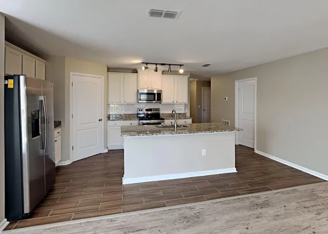 a view of kitchen with stainless steel appliances refrigerator sink and cabinets