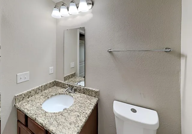 a bathroom with a granite countertop sink and a mirror