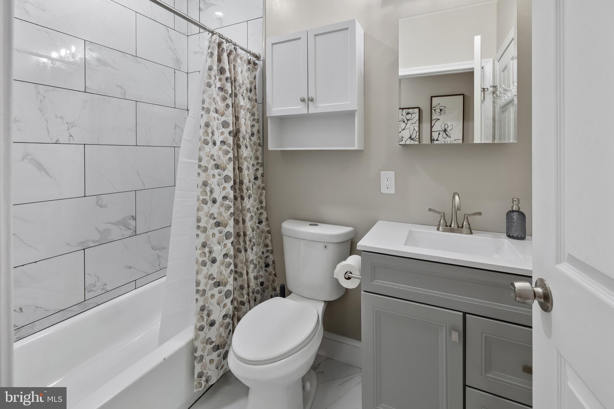 2202 East Chase Street Baltimore, MD 21213 - Photo 11 of 33 a bathroom with a sink a toilet and shower