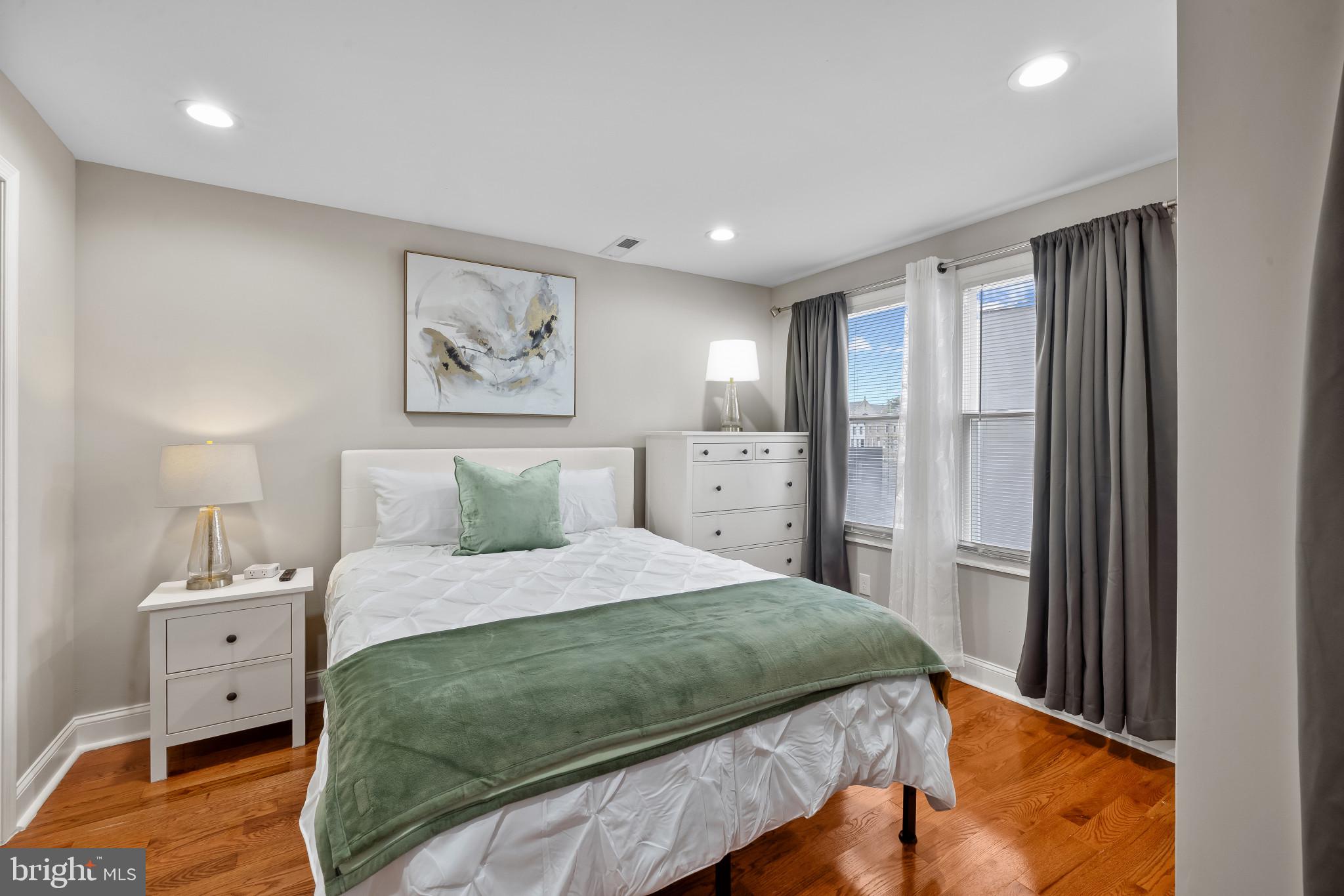 2202 East Chase Street Baltimore, MD 21213 - Photo 22 of 33 a bedroom with a large bed and a chandelier