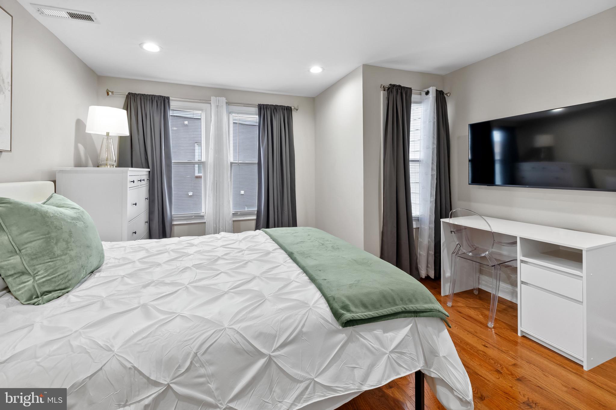 2202 East Chase Street Baltimore, MD 21213 - Photo 23 of 33 a bedroom with a bed and a flat screen tv