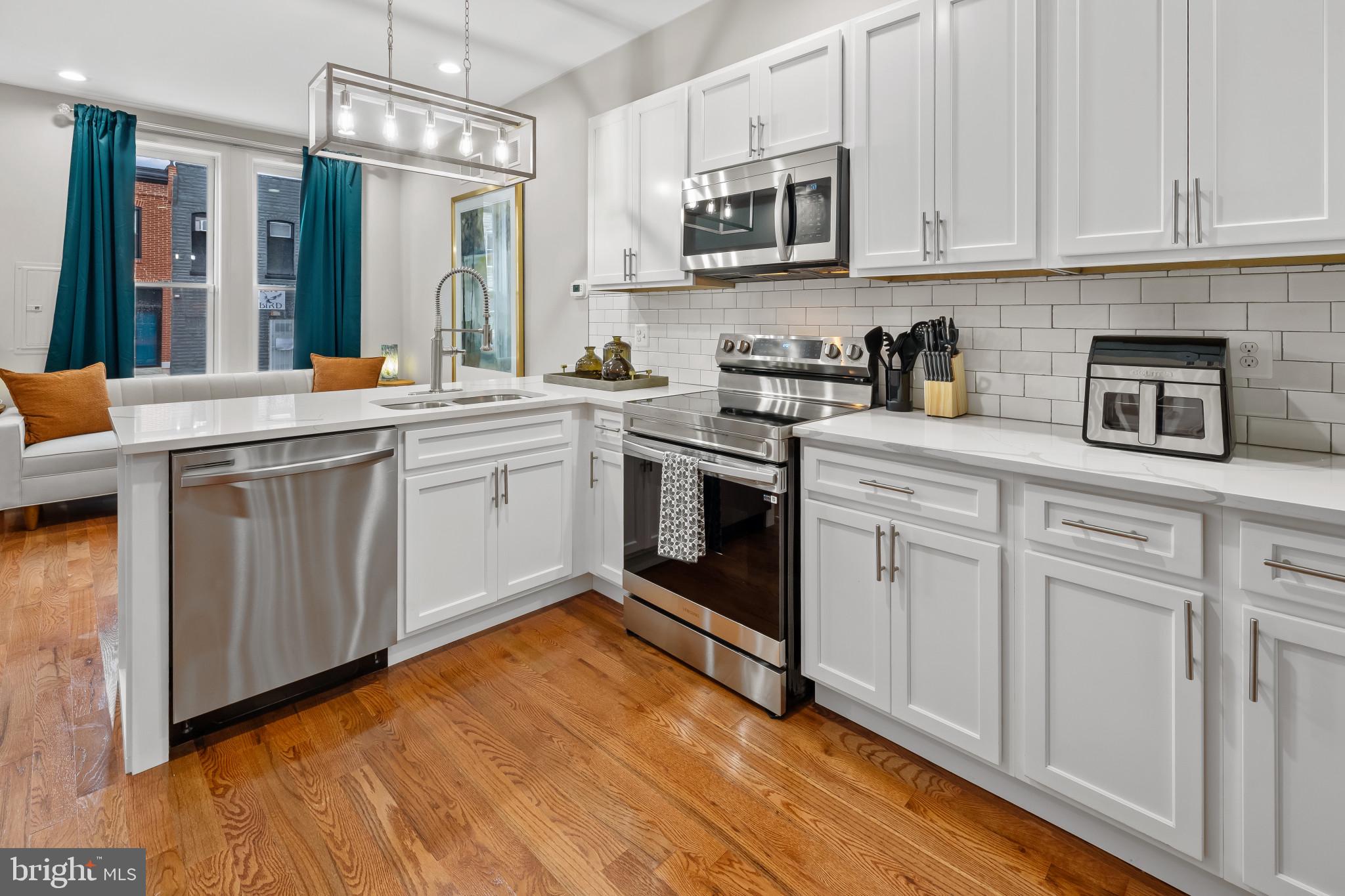 2202 East Chase Street Baltimore, MD 21213 - Photo 5 of 33 a kitchen with stainless steel appliances granite countertop a sink and cabinets