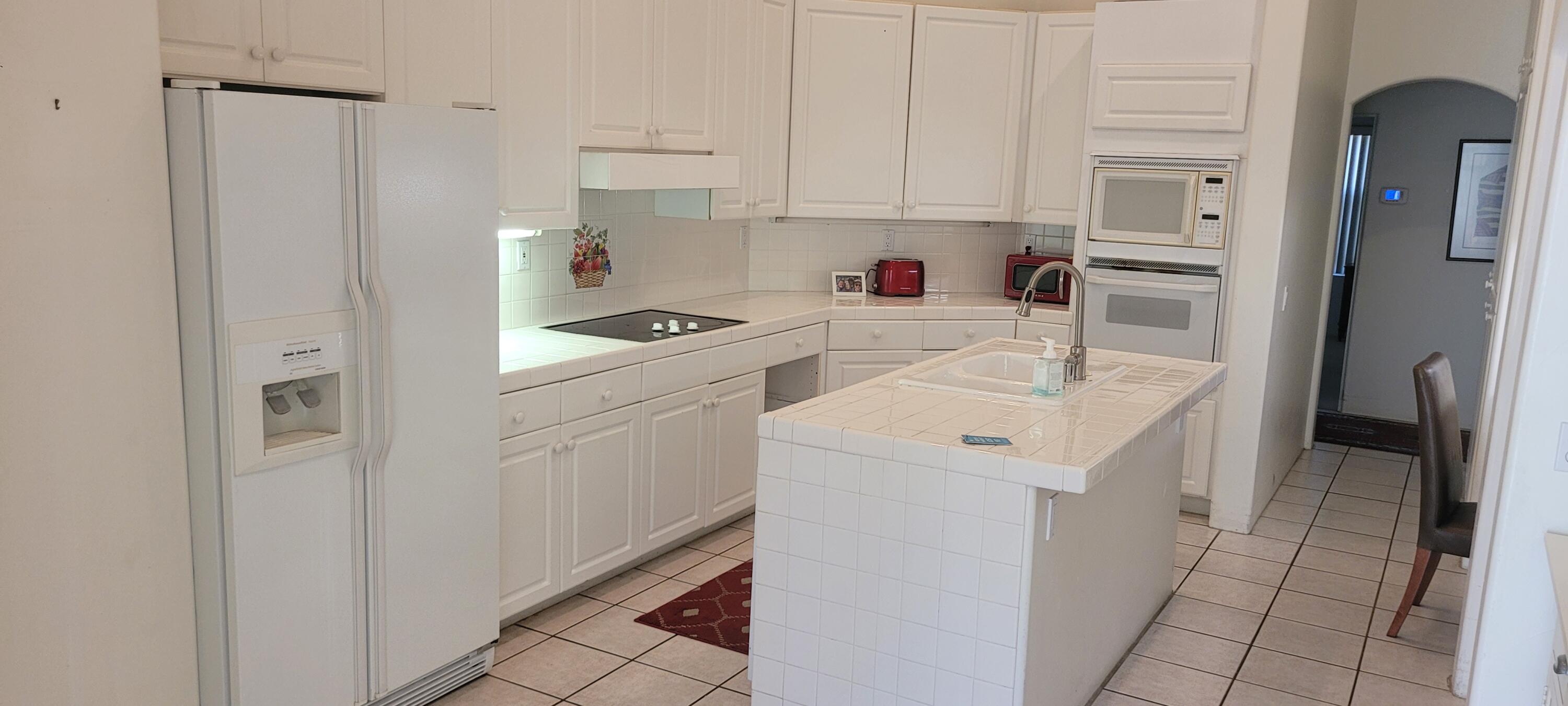 39914 Morningsprings Road Rancho Mirage, CA 92270 - Photo 29 of 54 a kitchen with a sink a stove a refrigerator and cabinets