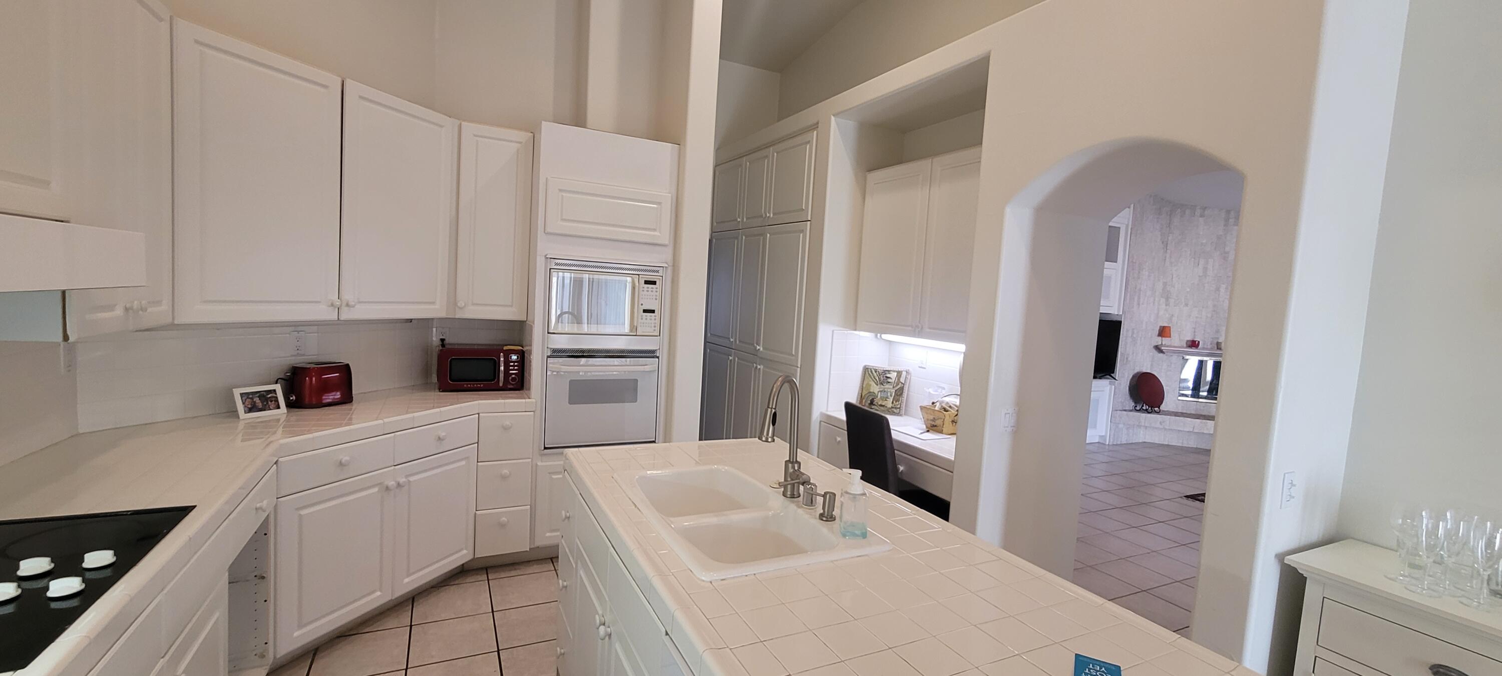 39914 Morningsprings Road Rancho Mirage, CA 92270 - Photo 30 of 54 a kitchen with white cabinets and refrigerator