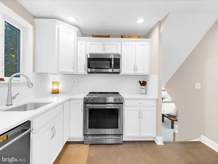a kitchen with stainless steel appliances a stove microwave and sink