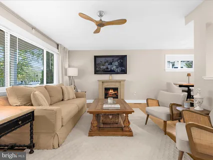 a living room with furniture a fireplace and a large window