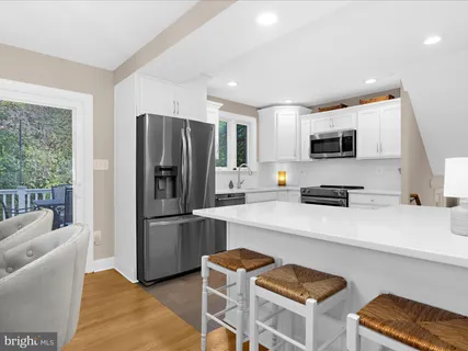 a kitchen with stainless steel appliances kitchen island granite countertop a stove a sink a dining table and chairs